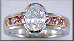 Oval Diamond set with 6 brilliant Pink Diamonds in a custom rose gold and platinum ring.