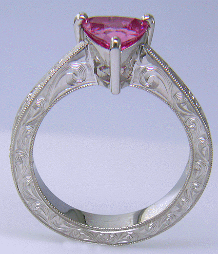 Side view of hand engraved platinum ring with a trillium pink sapphire.