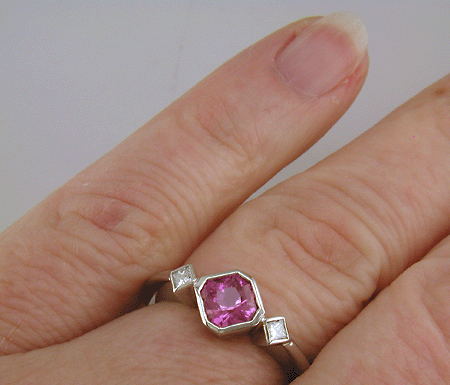 Pink Sapphire set with two Princess-cut diamonds in a platinum ring. (J8547)