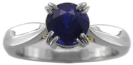 Platinum sapphire ring with two hidden diamonds and 18kt gold accents.
