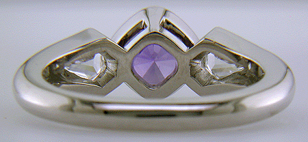 Inside view of purple sapphire set with two calf head diamonds in a platinum ring.