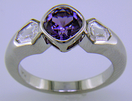 Purple sapphire set with two calf-head diamonds in a platinum ring.