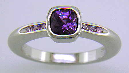 Cushion-cut purple sapphire with round lilac sapphires in a custom platinum ring.