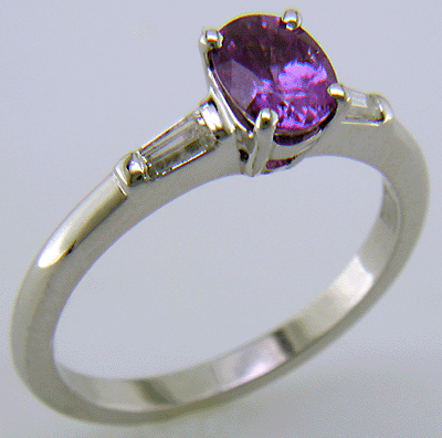 An oval Purple Sapphire set with tapered baguette diamonds in a custom platinum ring.