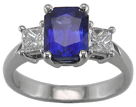 Radiant-cut sapphire and two princess-cut diamonds in a stiking platinum ring.