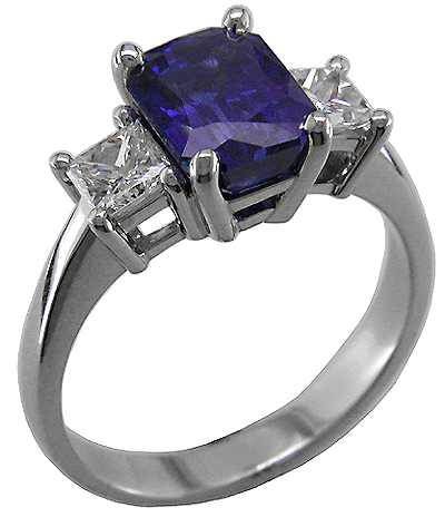 Radiant-cut sapphire ring with two princess-cut diamonds.