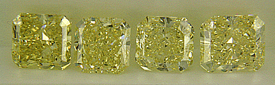 Line up of four fancy yellow diamonds.