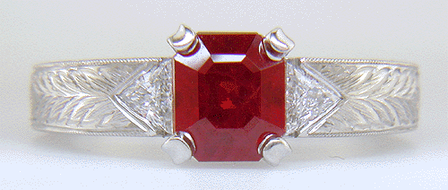 An emerald-cut ruby set in a platinum hand-engraved ring.