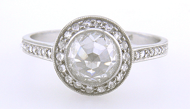 Rose-cut diamond set in a platinum ring accented with small Rose-cut diamonds.