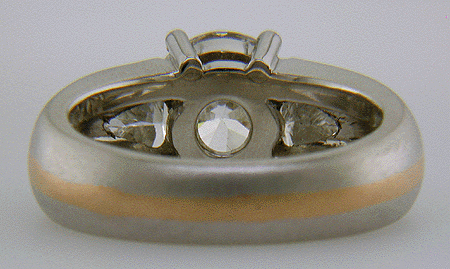 Inside view of platinum and rose gold ring with an ideal-cut diamond and trilliants.