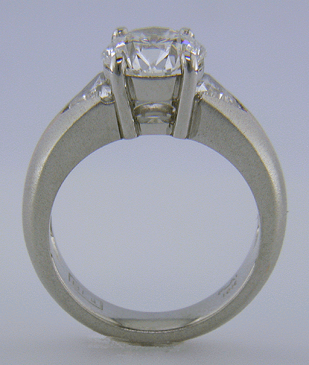 Side of view of platinum and rose gold ring with an ideal-cut diamond and trilliants.