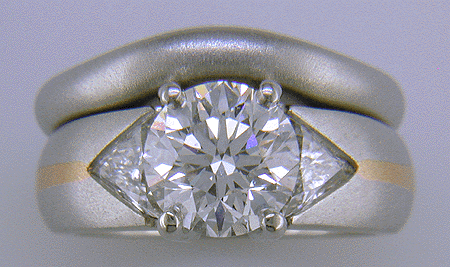 Platinum and rose gold ring with an ideal-cut diamond and trilliants.
