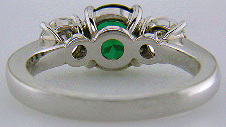 Inside view of diamond and emerald ring in platinum.