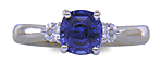 Cushion-cut Sapphire set with two round diamonds in a handcrafted platinum ring.