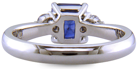 Emerald-cut sapphire set with two round diamonds in a handcrafted platinum ring. (J8540)