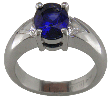 Platinum ring with an oval sapphire and trilliant diamonds.