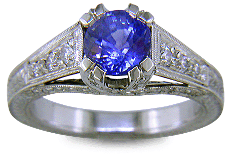 A bright sapphire set with 42 accenting diamonds in an engraved platinum ring. (J6410)