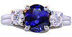 Platinum trellis ring set with an oval sapphire and two diamonds.