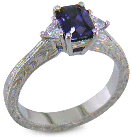 Hand engraved radiant-cut sapphire and trilliant diamond ring in platinum.