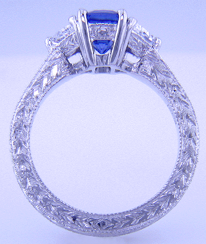 Side view of hand-engraved platinum ring with cushion sapphire and diamonds.