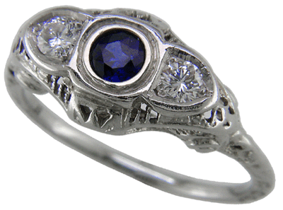 An antique filigree ring with a sapphire and two diamonds.