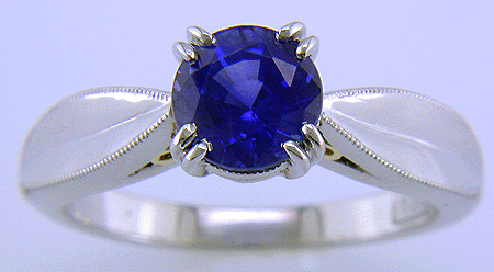 Platinum sapphire ring with two hidden diamonds and 18kt gold accents.