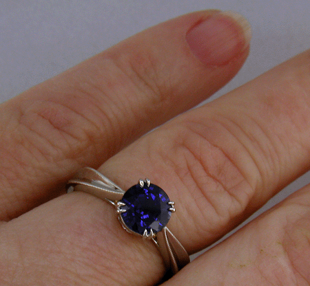 Sapphire ring crafted in platinum with two hidden diamonds and gold accents. (J8751)