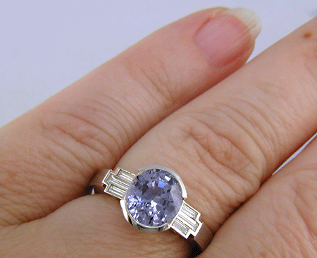 A handcrafted platinum ring with a steely blue Sapphire and sparkling baguette diamonds. (J8516)