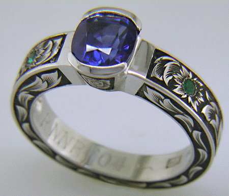 A cushion-cut Sapphire set in a beautifully hand crafted and engraved platinum ring.