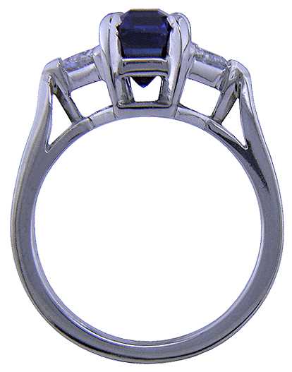 Side view of handcrafted platinum ring with a sriking emerald-cut sapphire and two sparkling trilliant diamonds.