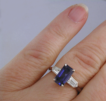 A handcrafted platinum ring with a sriking emerald-cut Sapphire and sparkling bullet-shape diamonds.