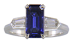 A handcrafted platinum ring with a sriking emerald-cut Sapphire and sparkling bullet-shape diamonds. (J7418)