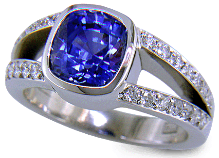 A cushion-cut sapphire set with diamonds in a custom platinum ring. (J6654)