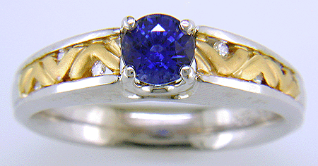 A blue sapphire set in an 18kt white gold ring with 22kt yellow gold shoulders.
