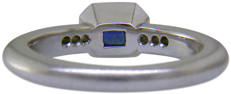 Inside view of emerald-cut sapphire set with round brilliant-cut diamonds in a custom platinum ring. (J6398)