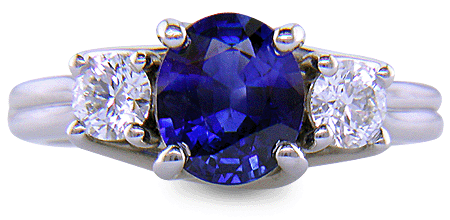 Platinum trellis ring set with an oval sapphire and two diamonds. (J6401)