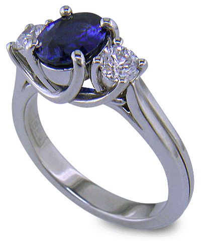 Platinum trellis ring set with an oval sapphire and two diamonds. (J6401)