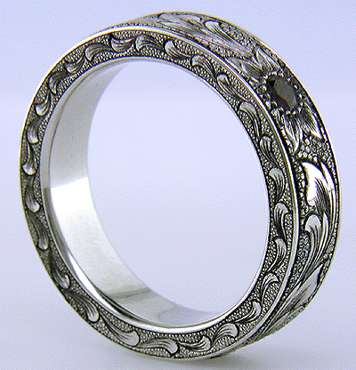 Side view of hand-engraved platinum band set with pyrope garnets.