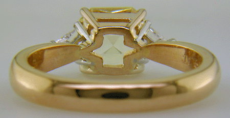 Inside view of yellow sapphire set with two trilliant diamonds in a handcrafted 18kt gold and platinum ring.