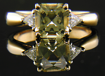 Yellow sapphire set with two trilliant diamonds in a handcrafted 18kt gold and platinum ring.