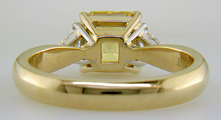 Inside view of yellow sapphire set with two trilliant diamonds in a handcrafted 18kt gold and platinum ring.