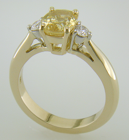 Cushion-cut Yellow Sapphire set with two brilliant-cut diamonds in a handcrafted 18kt gold and platinum ring.