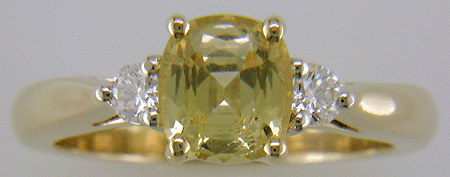 Cushion-cut Yellow Sapphire set with two brilliant-cut diamonds in a handcrafted 18kt gold and platinum ring.