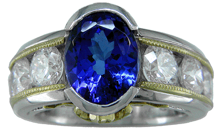 Oval tanzanite set with 6 brilliant diamonds in a custom platinum and gold ring.