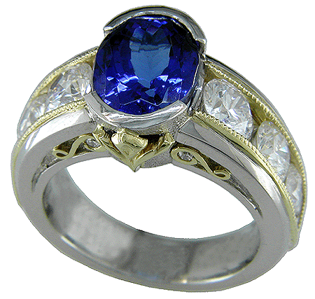 Oval tanzanite set with 6 brilliant diamonds in a custom platinum and gold ring.