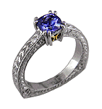 A tanzanite solitaire in hand engraved platinum rings.