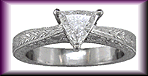 Trilliant diamond set in hand-engraved platinum ring.