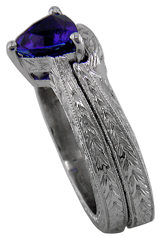Side view of platinum and sapphire engraved ring with matching band.