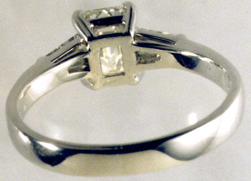Inside view of platinum engagement ring with emerald cut diamond and tapered diamond baguettes.