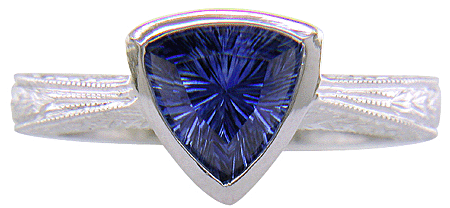 Concaved-faceted trillium Sapphire set in a handcrafted, hand-engraved platinum ring. (J8707)